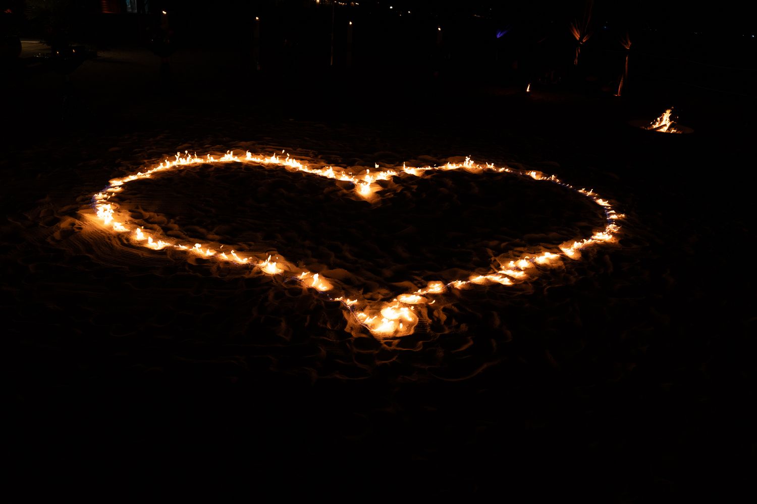 String of glowing lights creating a curved line against a dark night sky.