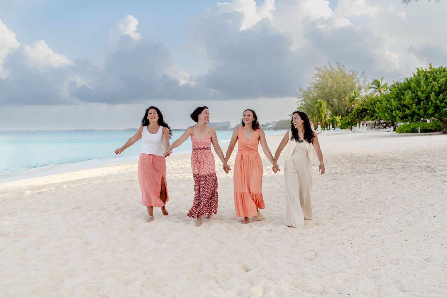 Family members in matching outfits strolling together on tropical beach.
