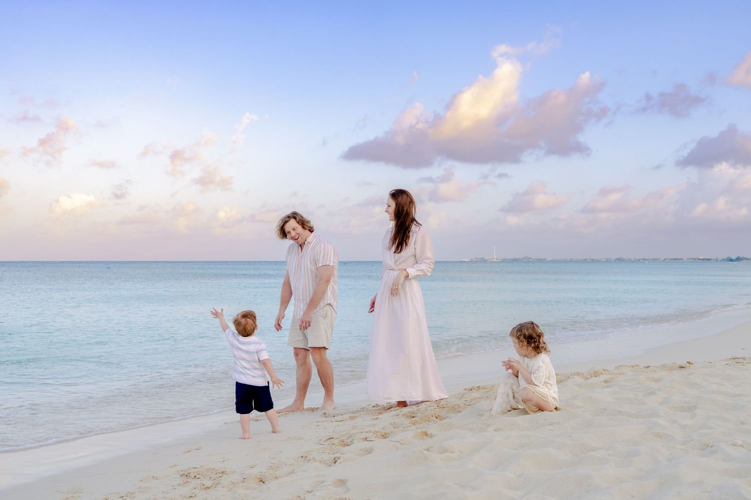 Natural family moments captured during a sunset beach session with ocean backdrop.
