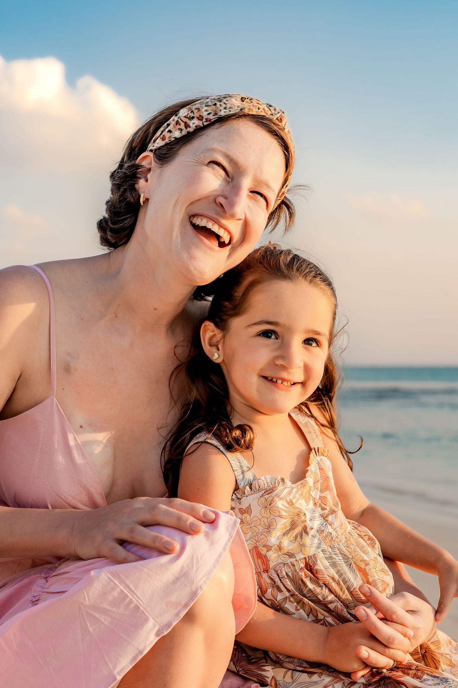 Candid moments of joy and laughter captured during a sunset beach photoshoot.