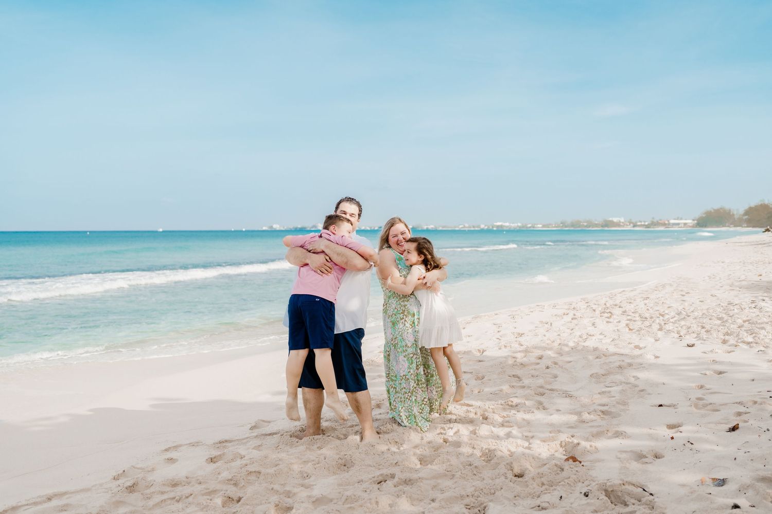 Group walking along pristine white sand beach with crystal clear turquoise waters and blue skies.