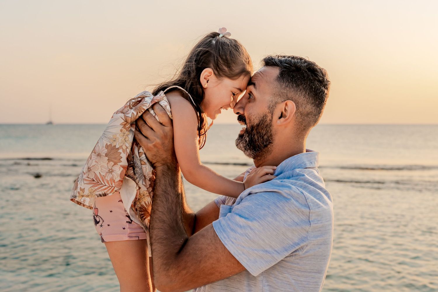 Romantic sunset beach photography session with gentle embraces by the ocean.