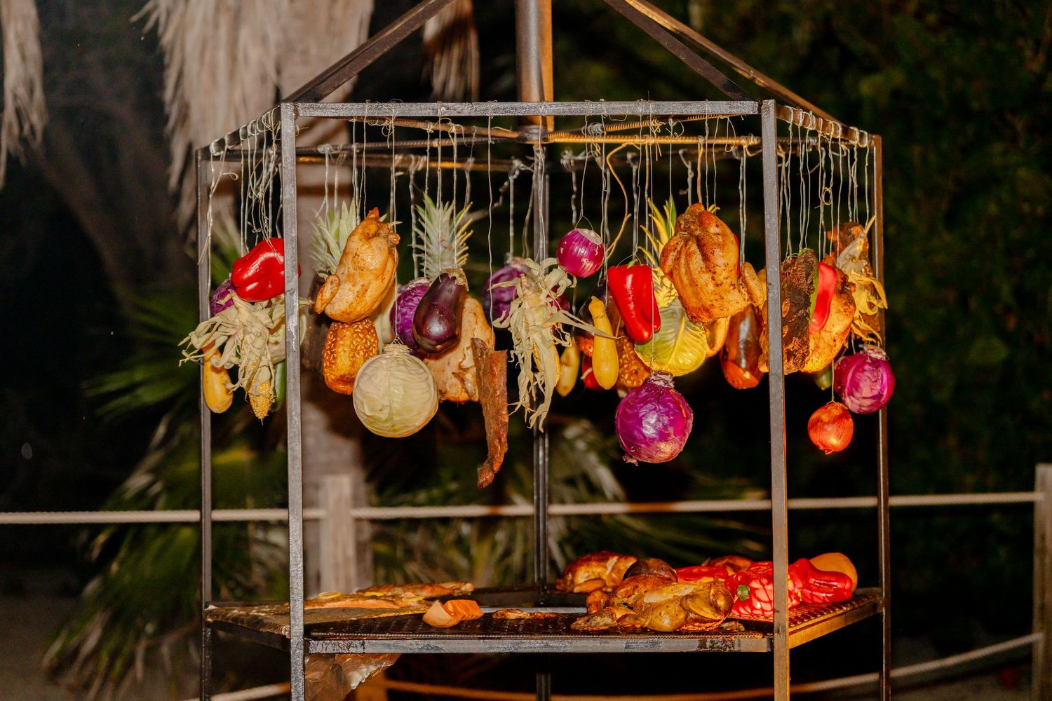 Colorful glass lanterns and decorative lights hanging from wooden beams at an outdoor event.