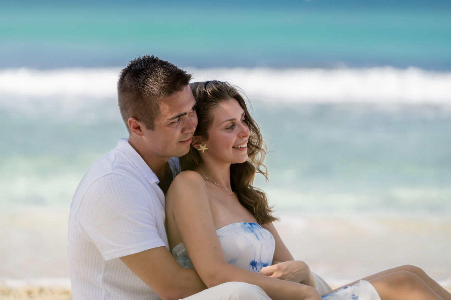 Romantic beach photoshoot with gentle waves and tropical turquoise waters.
