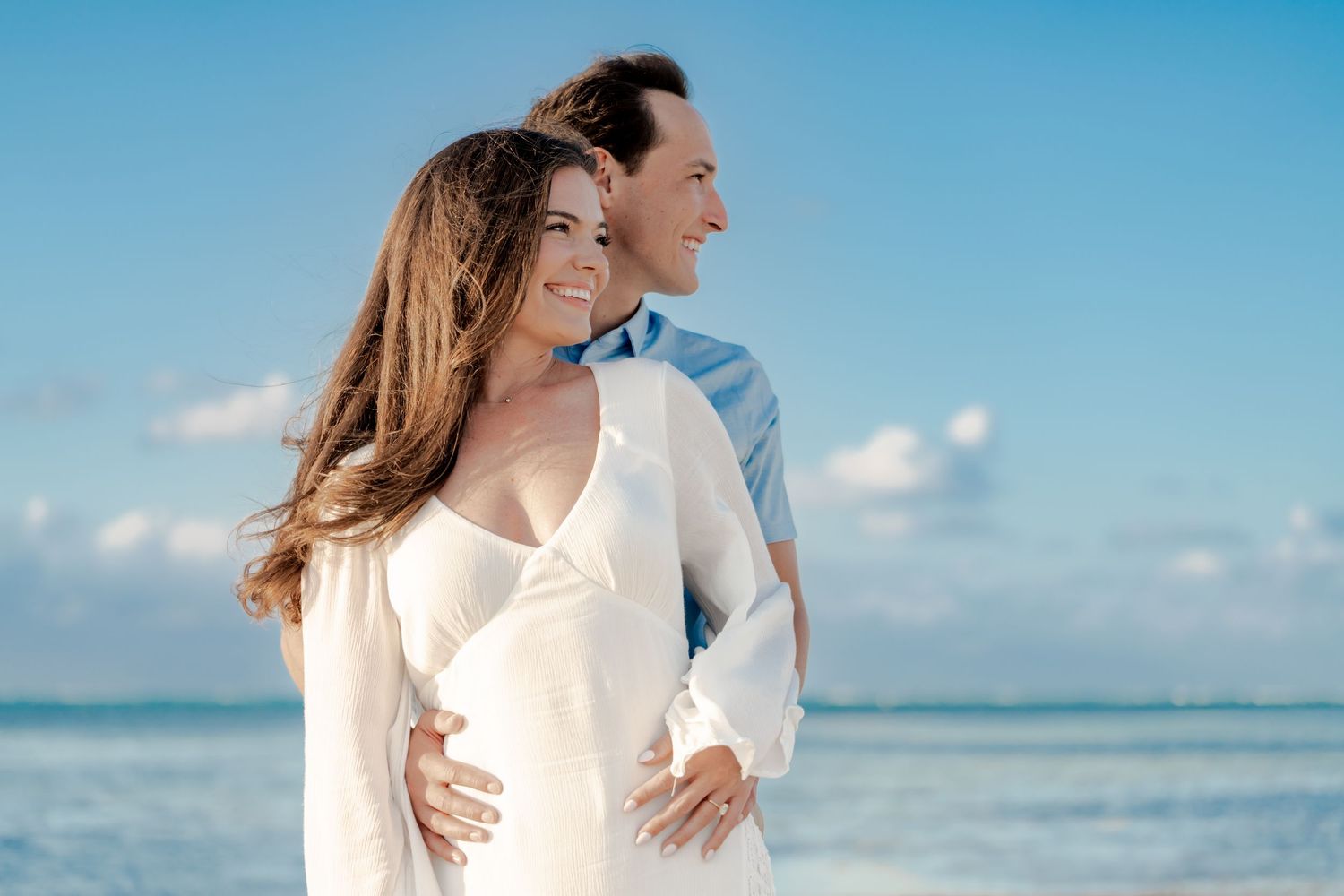 Romantic beach portrait with turquoise ocean and blue sky backdrop.