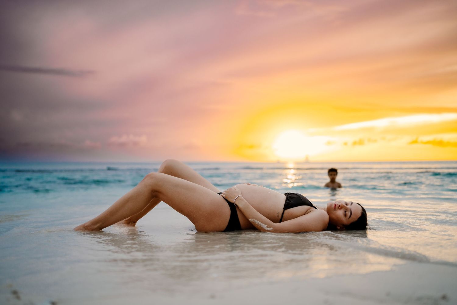 Beautiful beach sunset scene with golden light reflecting on ocean waves.