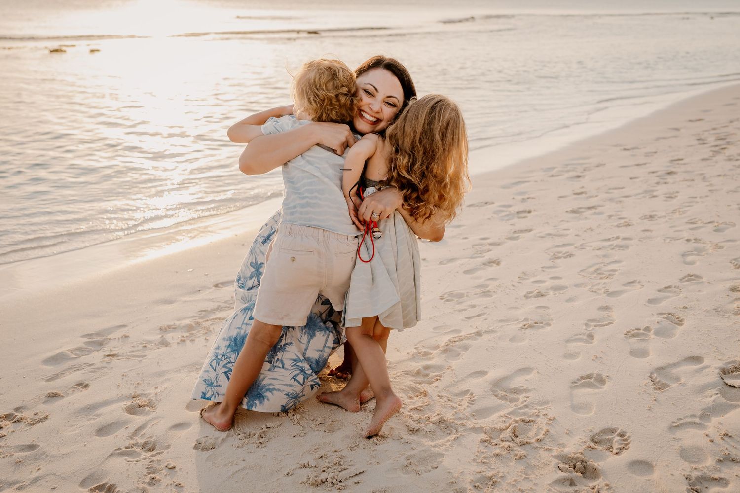 Playful beach photography session with couples on sandy shoreline at dusk.