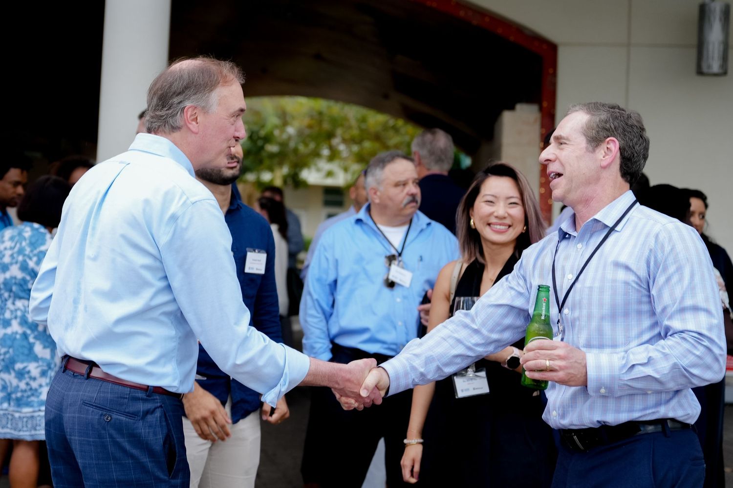 Business professionals mingling and networking at an indoor corporate event.