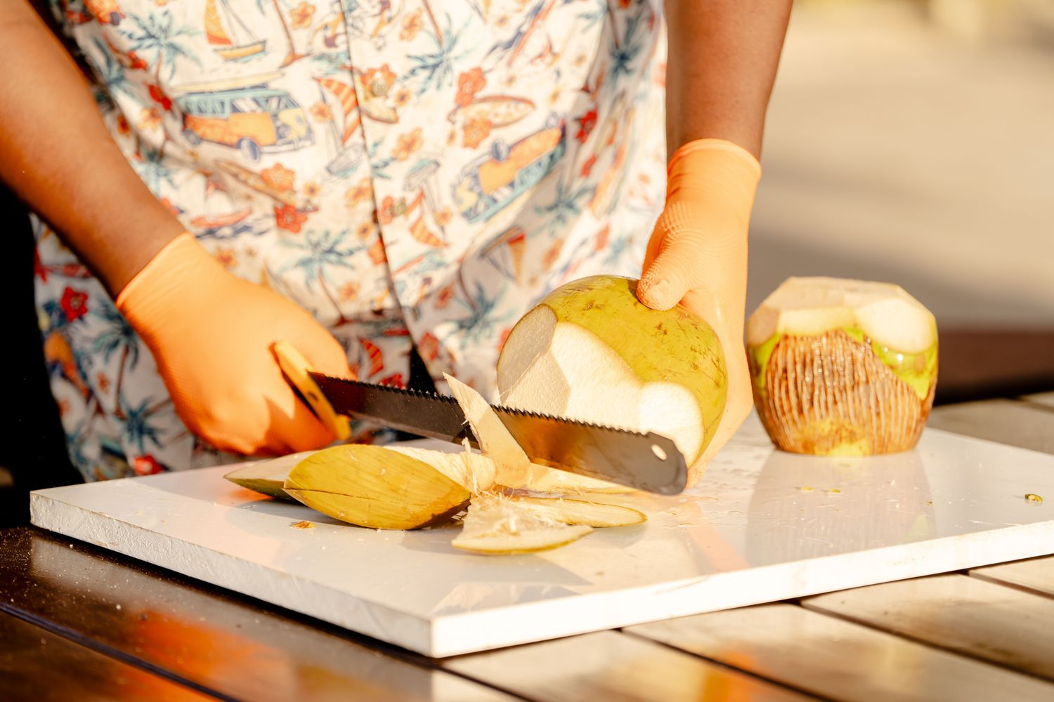 Hands preparing fresh fruit and ingredients on a wooden cutting board.
