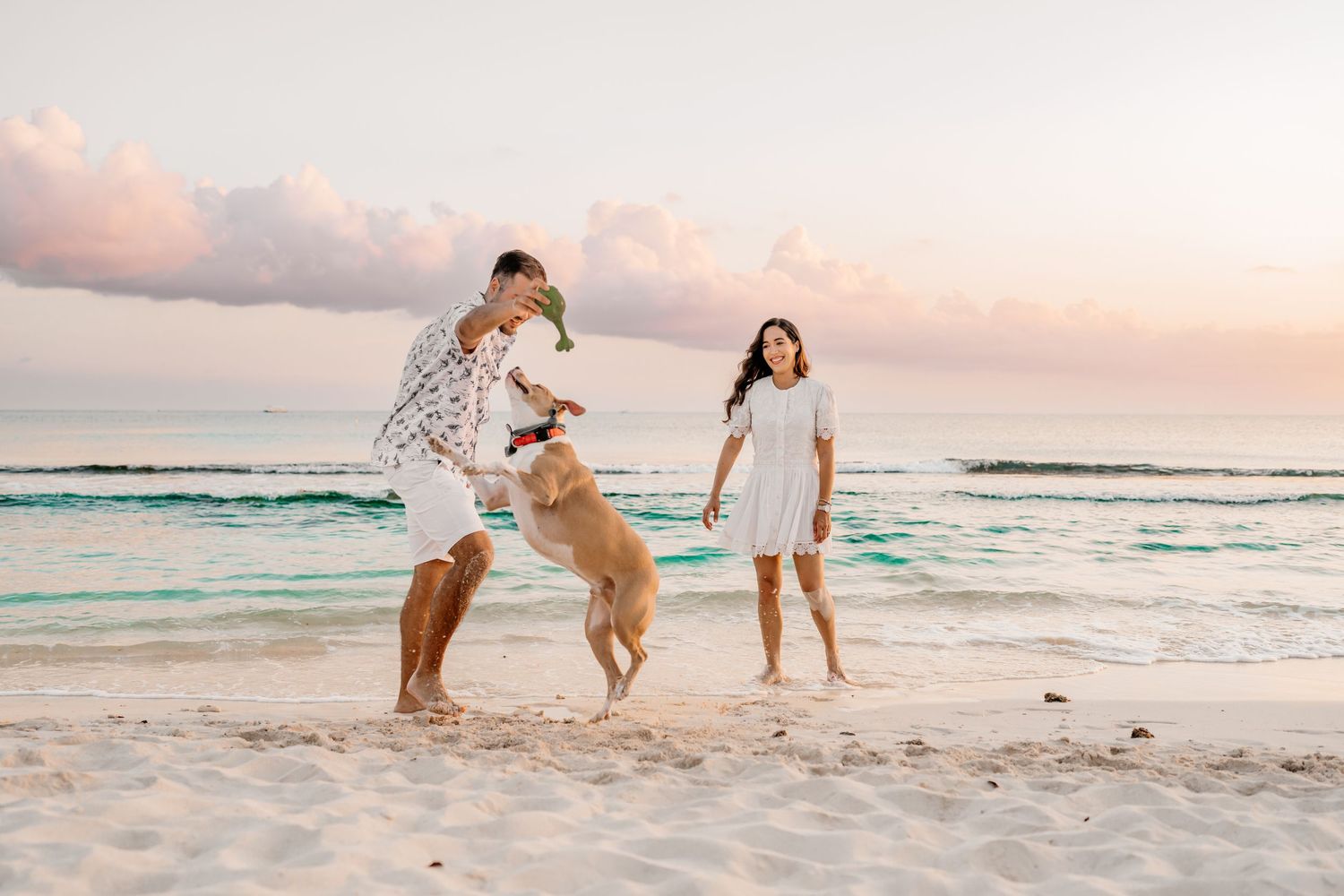 Candid beach photo of people running and playing in the sand during a beautiful sunset.