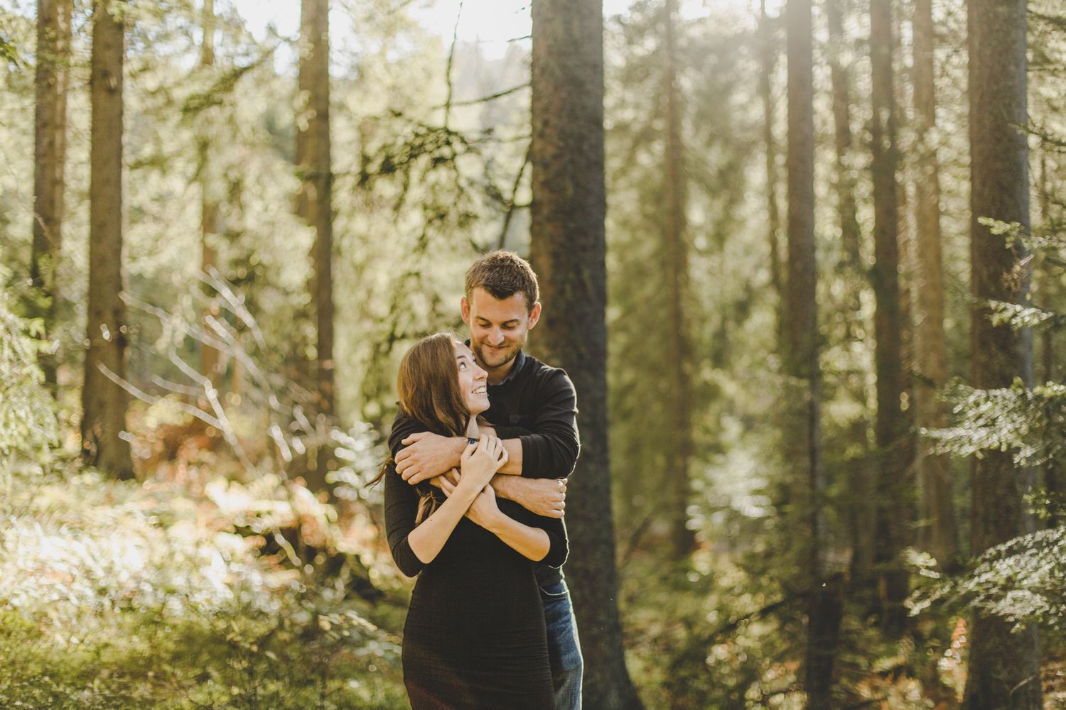 A couple enjoying their engagement session captured by natural candid Morzine Wedding Photographer. Woodland proposal in the French Aps