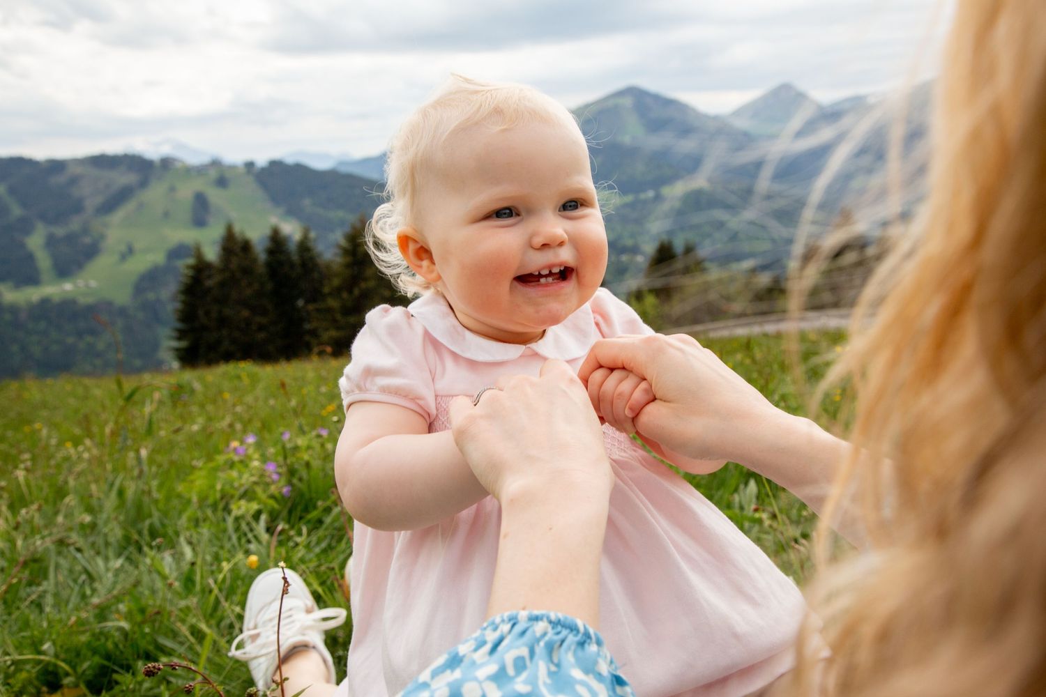 Outdoor family photography session with a mountain backdrop. Captured by Morzine Family photographer. Natural family portraits in morzine