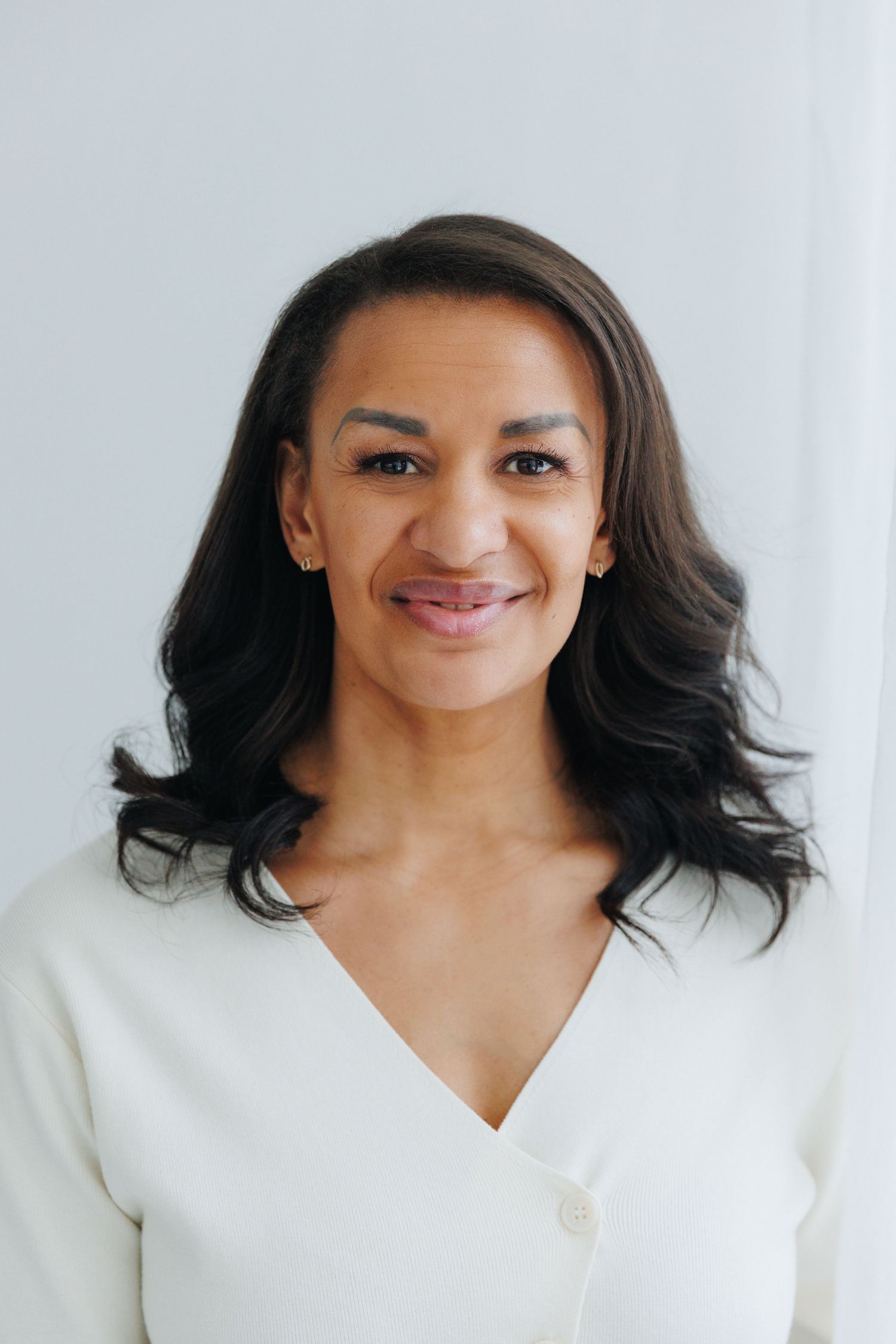 Dynamic headshots featuring a warm expression and dark hair against a minimalist white backdrop.