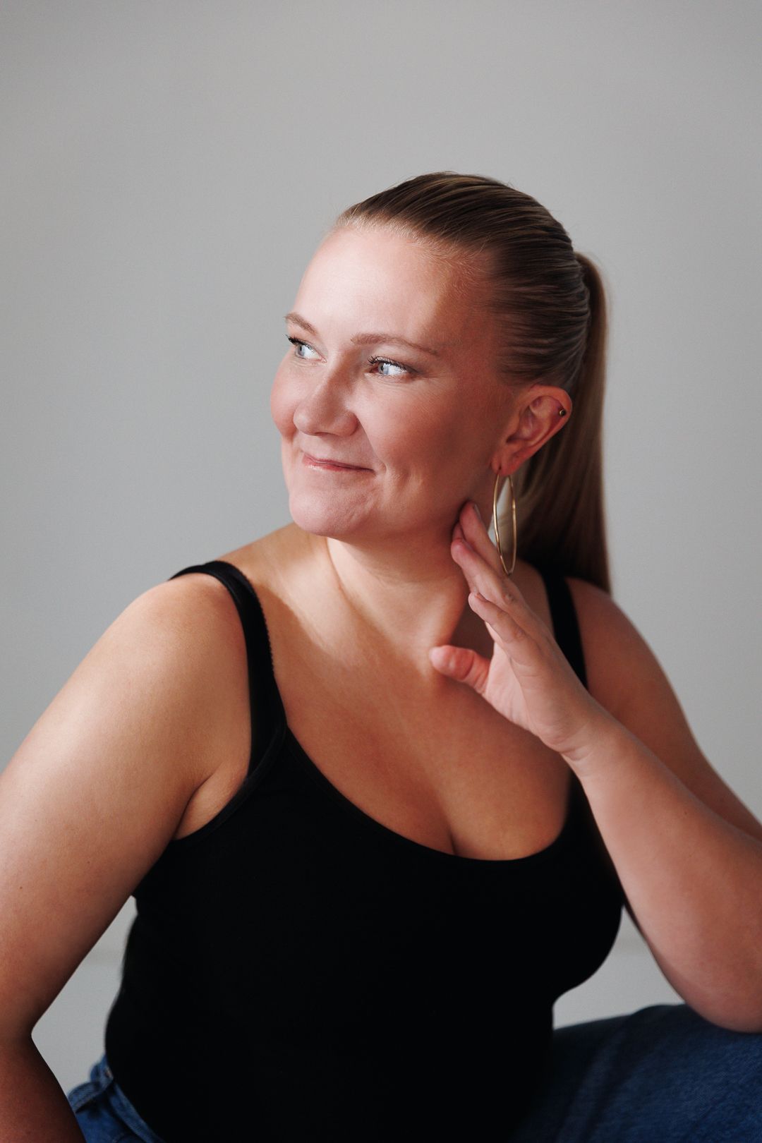 A series of photos showing someone in a black tank top posing thoughtfully against a gray background.
