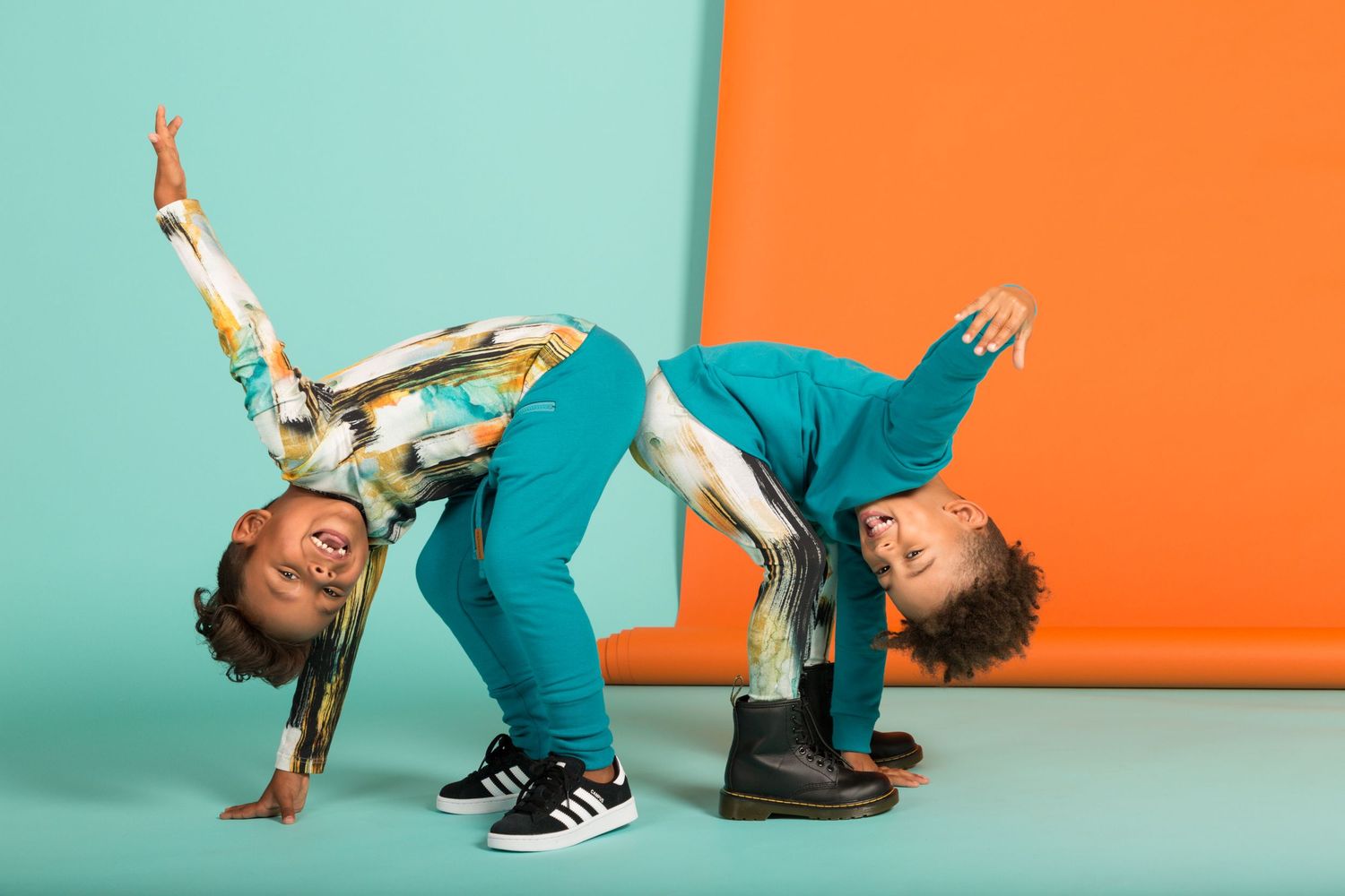 A sequence of dance movements with a person in teal pants and black sneakers performing against orange and blue backgrounds.