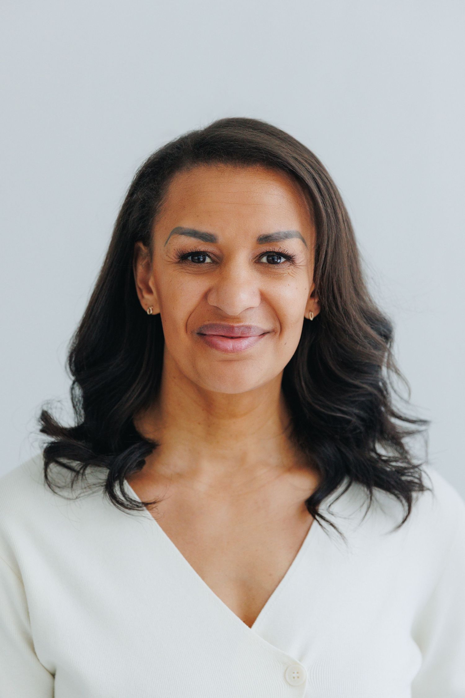 A series of four headshots showing joyful expressions and natural dark hair against a light background.