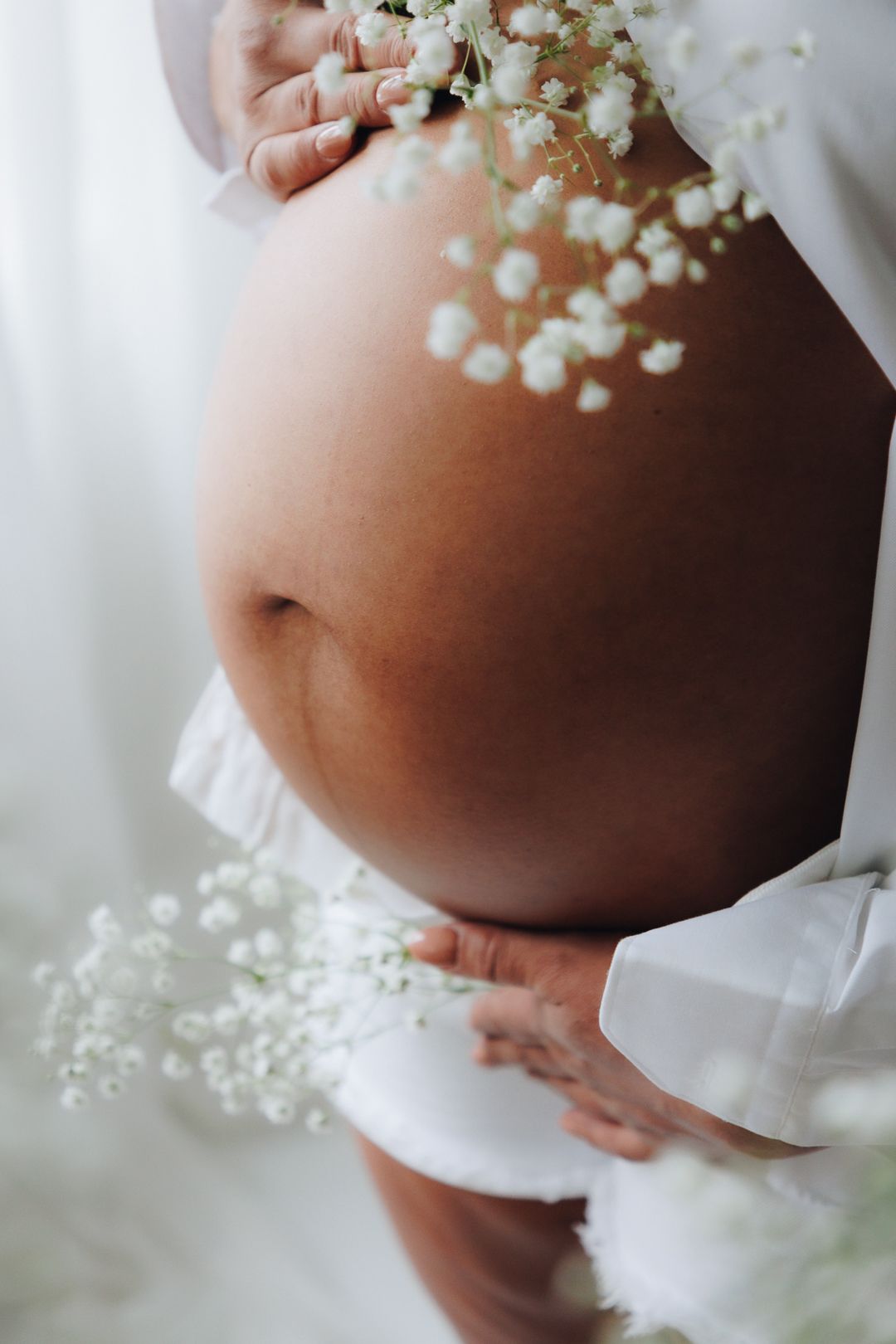 White baby's breath flowers create a delicate floral crown detail against a soft blurred background.