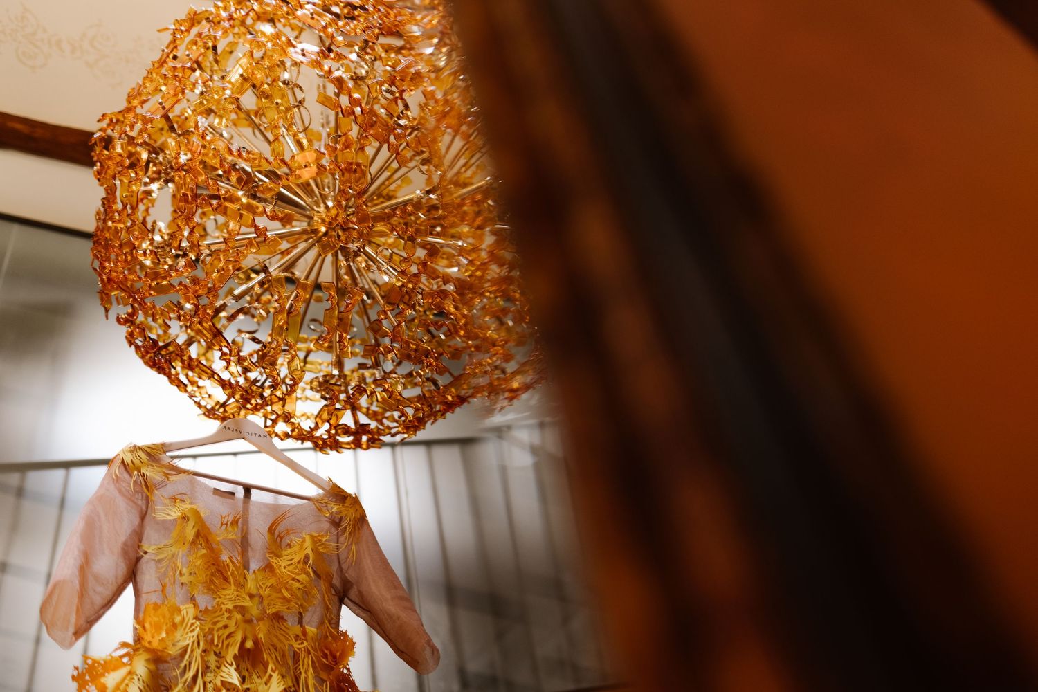 A modern gold sputnik chandelier with intricate geometric patterns casts warm light against a white ceiling.