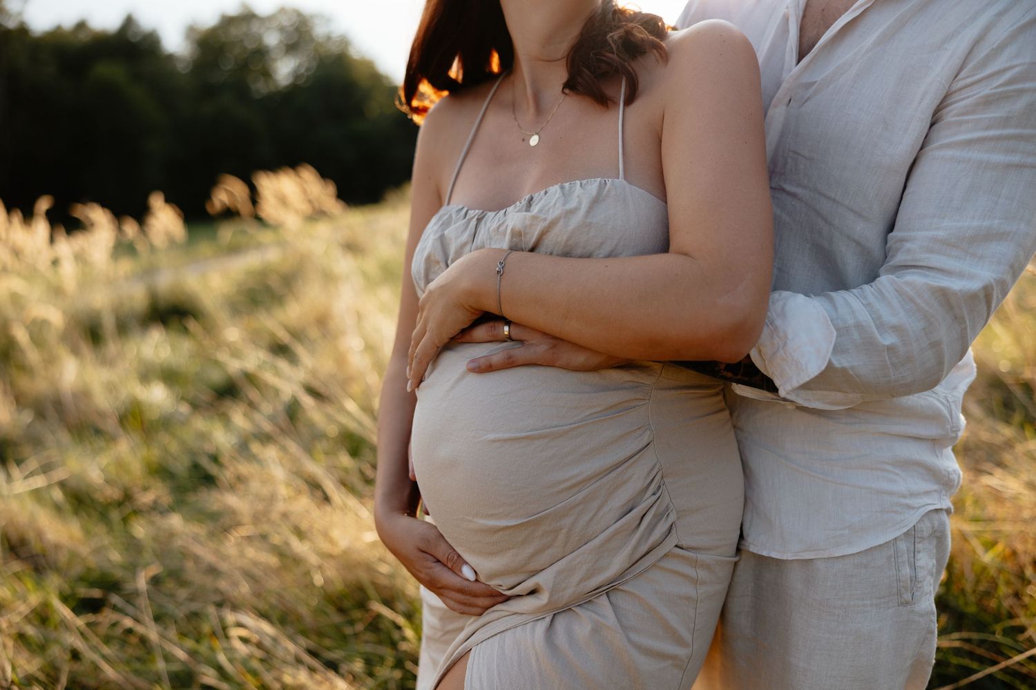 Intimate maternity portraits captured during golden hour in nature.