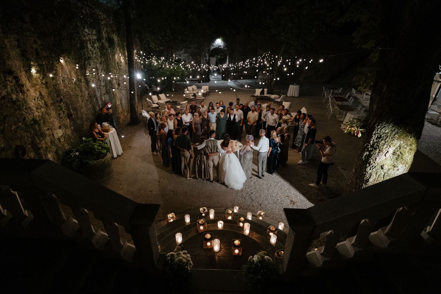 String lights create a magical ambiance at an outdoor wedding reception venue.