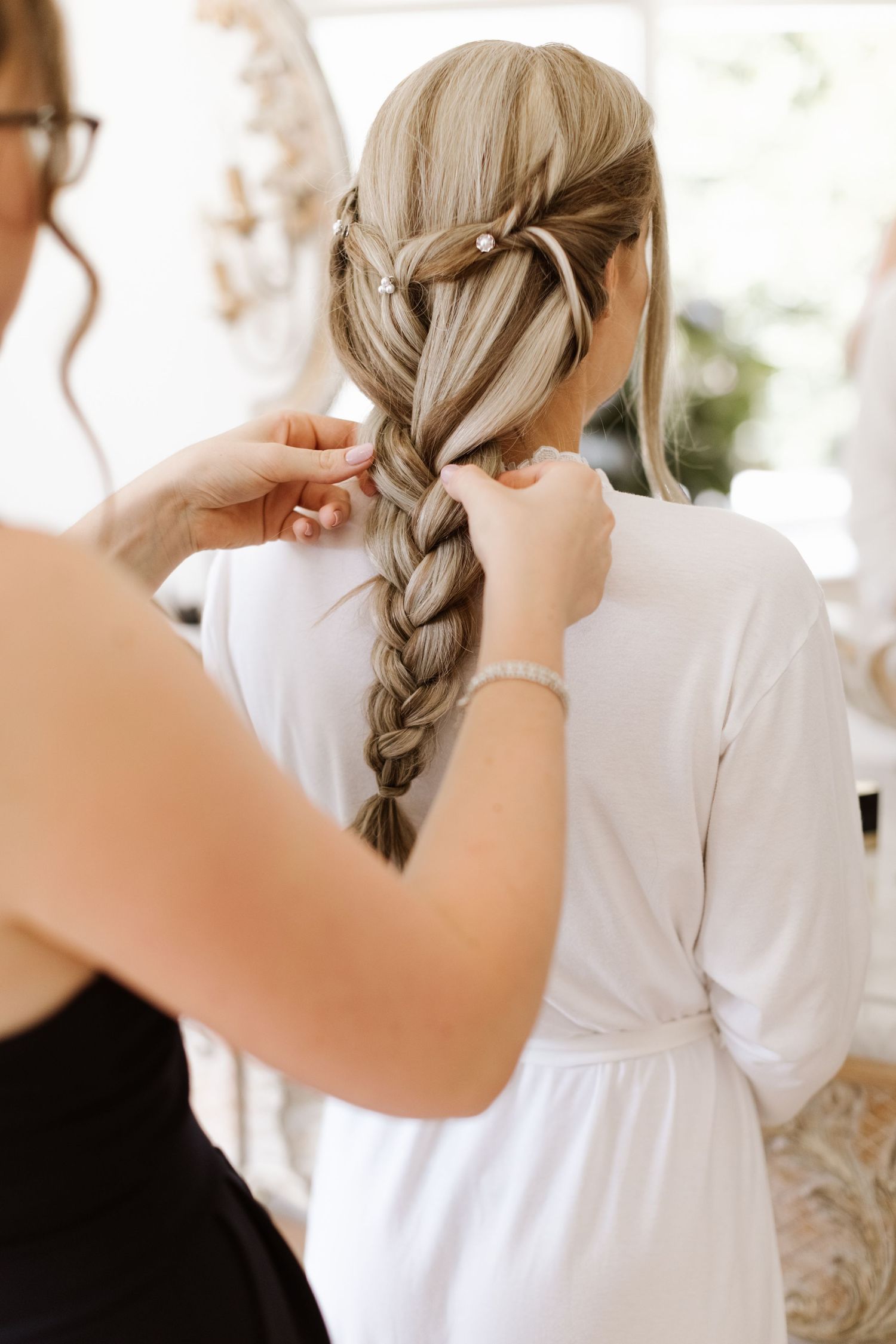 A series of photos showing someone braiding long blonde hair in a classic French braid style.
