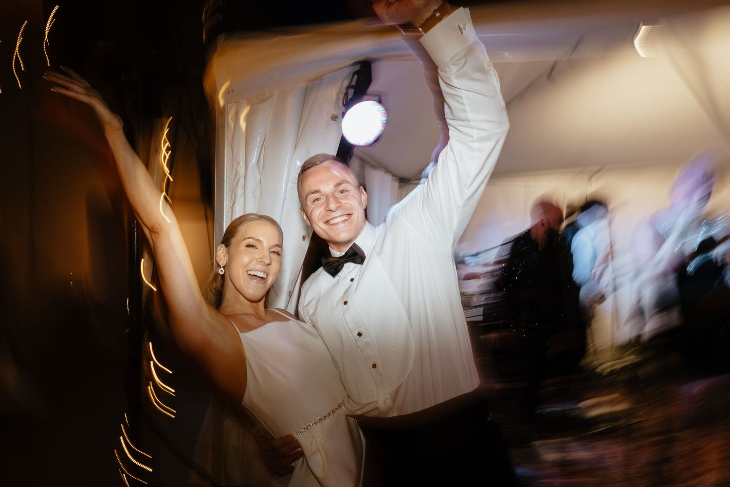 Wedding reception dance floor moments captured in motion blur and ambient lighting.