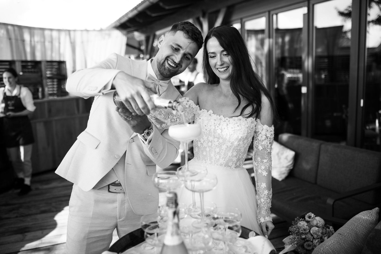 Wedding party enjoying champagne toast during outdoor celebration at sunset.