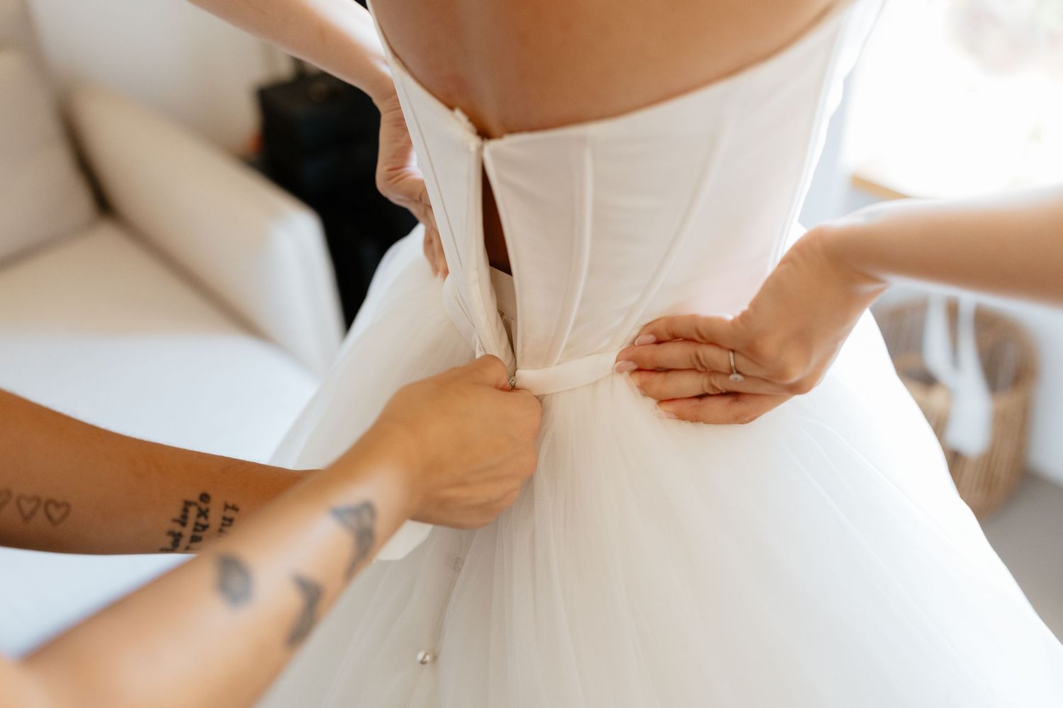 Close-up details of white wedding dress fastenings and fabric.