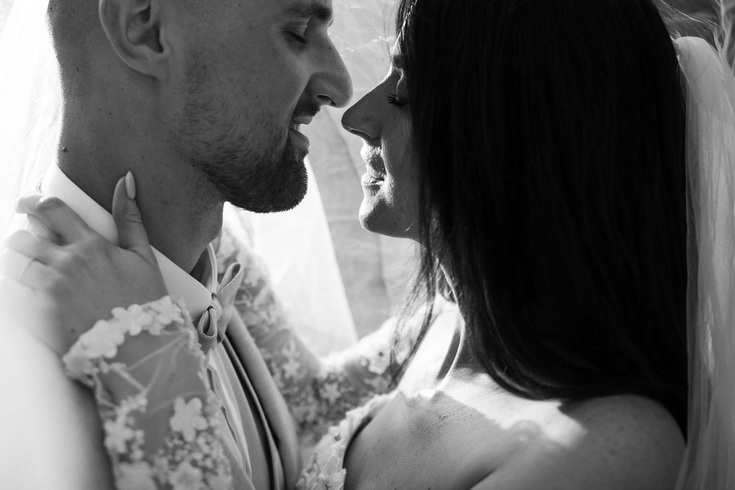 Black and white romantic moment between newlyweds sharing an intimate moment at their wedding celebration.