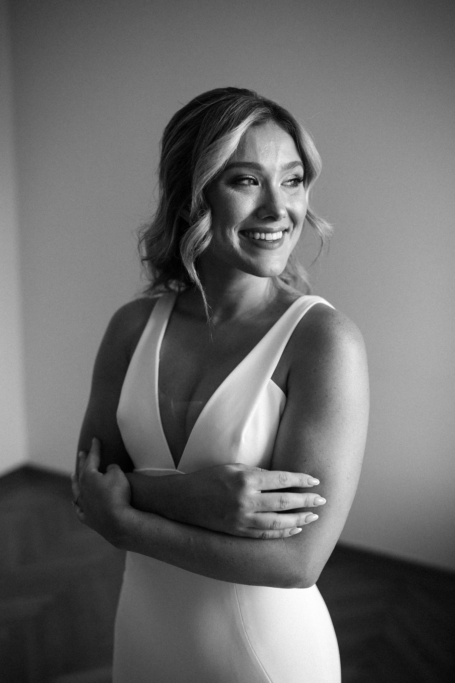 Black and white portraits capture candid moments of a bride in her wedding dress.
