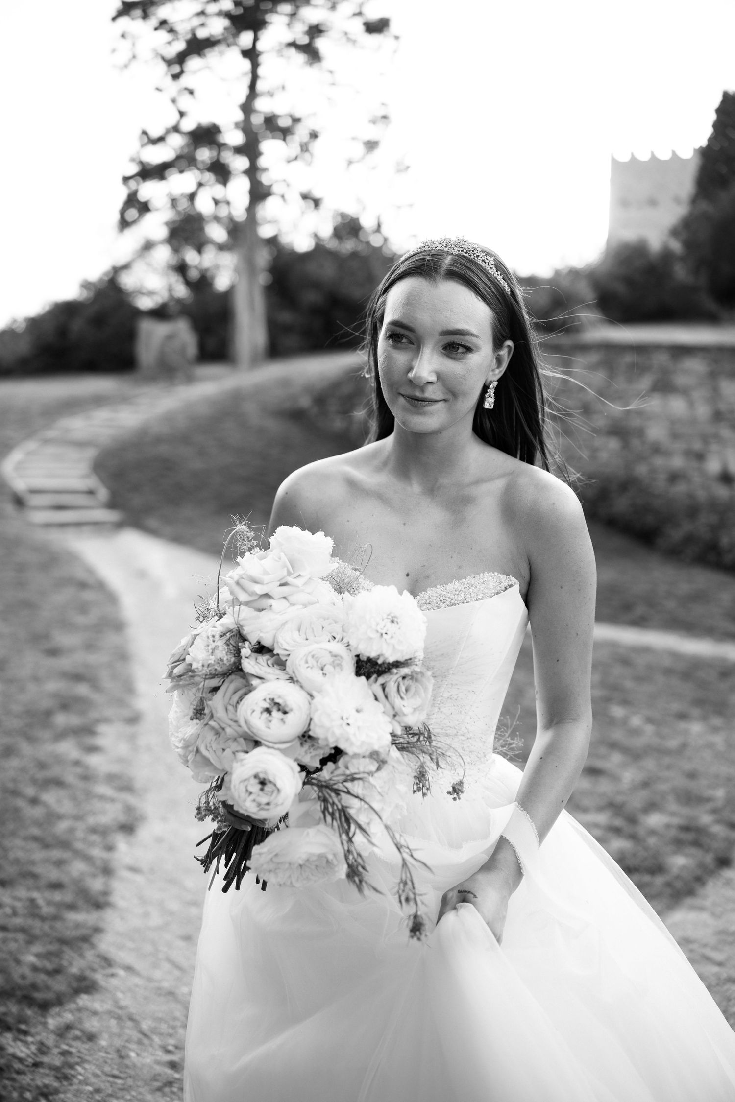 Elegant bridal portrait with white peony bouquet in outdoor setting.