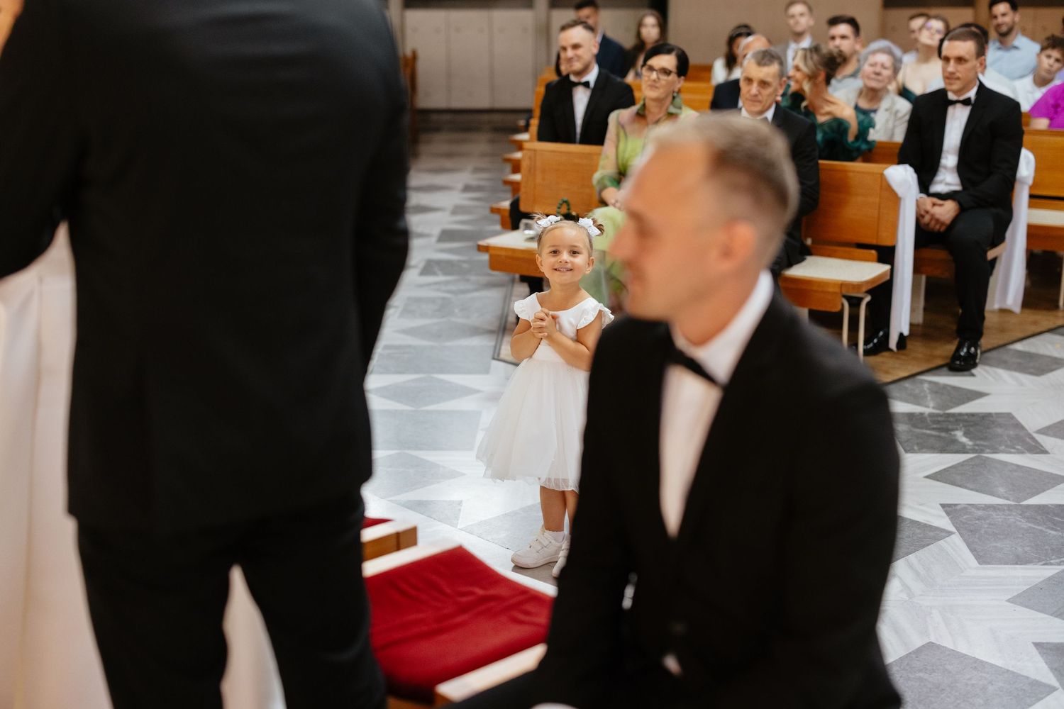 Church wedding ceremony with guests and a teddy bear in attendance.