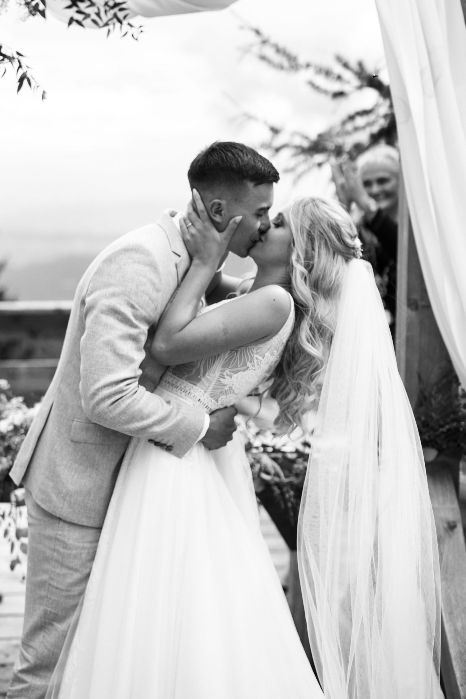 Black and white wedding ceremony photos showing romantic moments under a white veil.