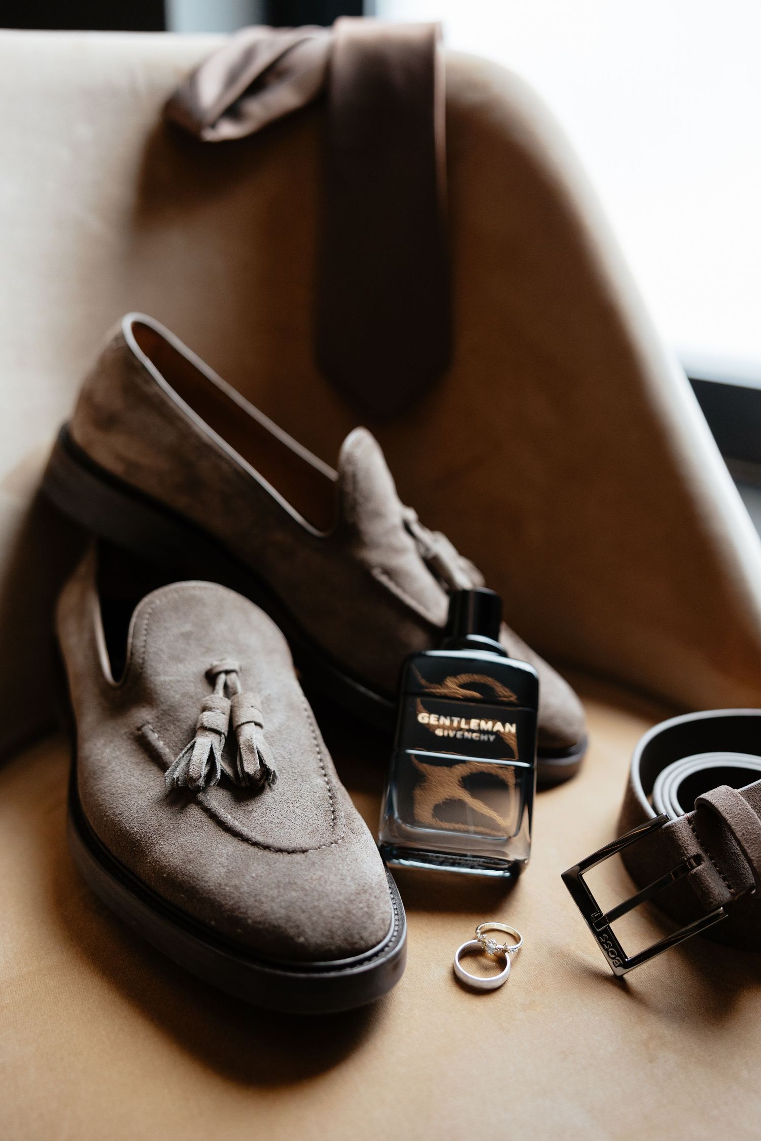 Close-up details of brown leather groomsmen shoes arranged artistically for wedding day photography.