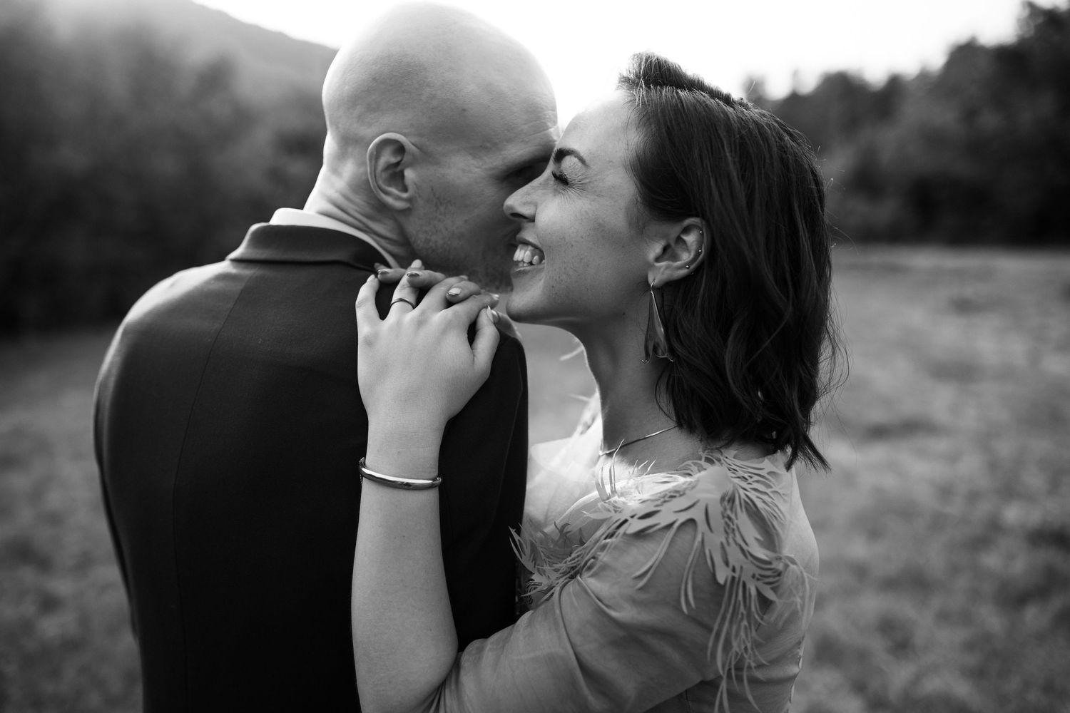 Intimate black and white portraits of a couple sharing tender moments outdoors.