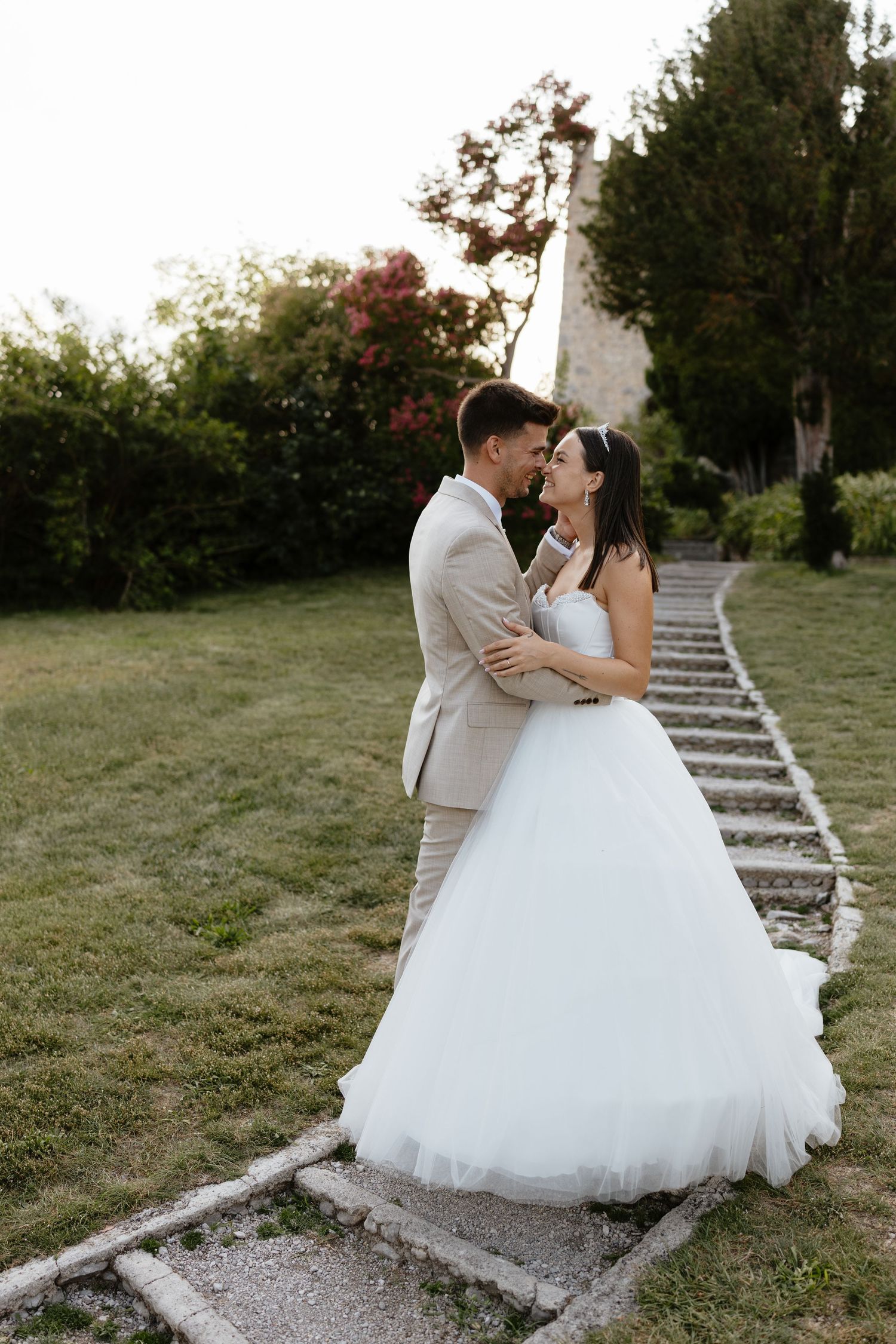 Romantic wedding couple shares intimate moments on garden stone steps.
