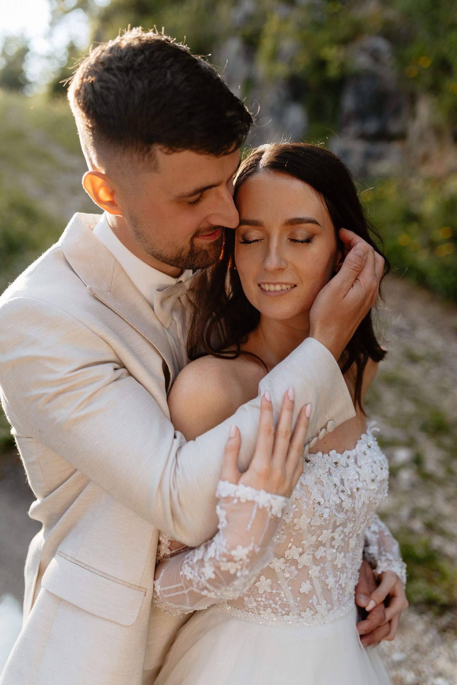 Couple shares tender romantic moments in a natural outdoor setting during their wedding photoshoot.