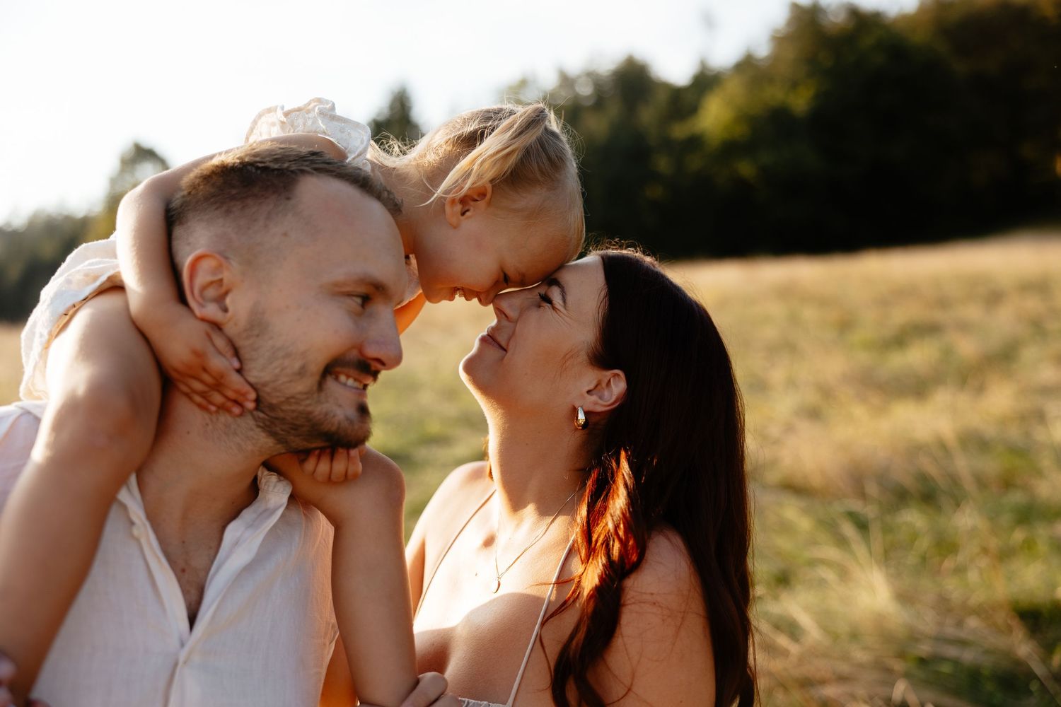 Romantic sunset portraits of a couple sharing intimate moments in a field.