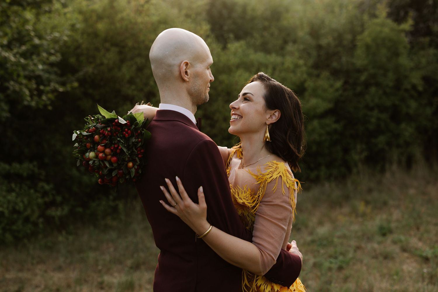 A heartfelt embrace between people in a garden setting with natural lighting.
