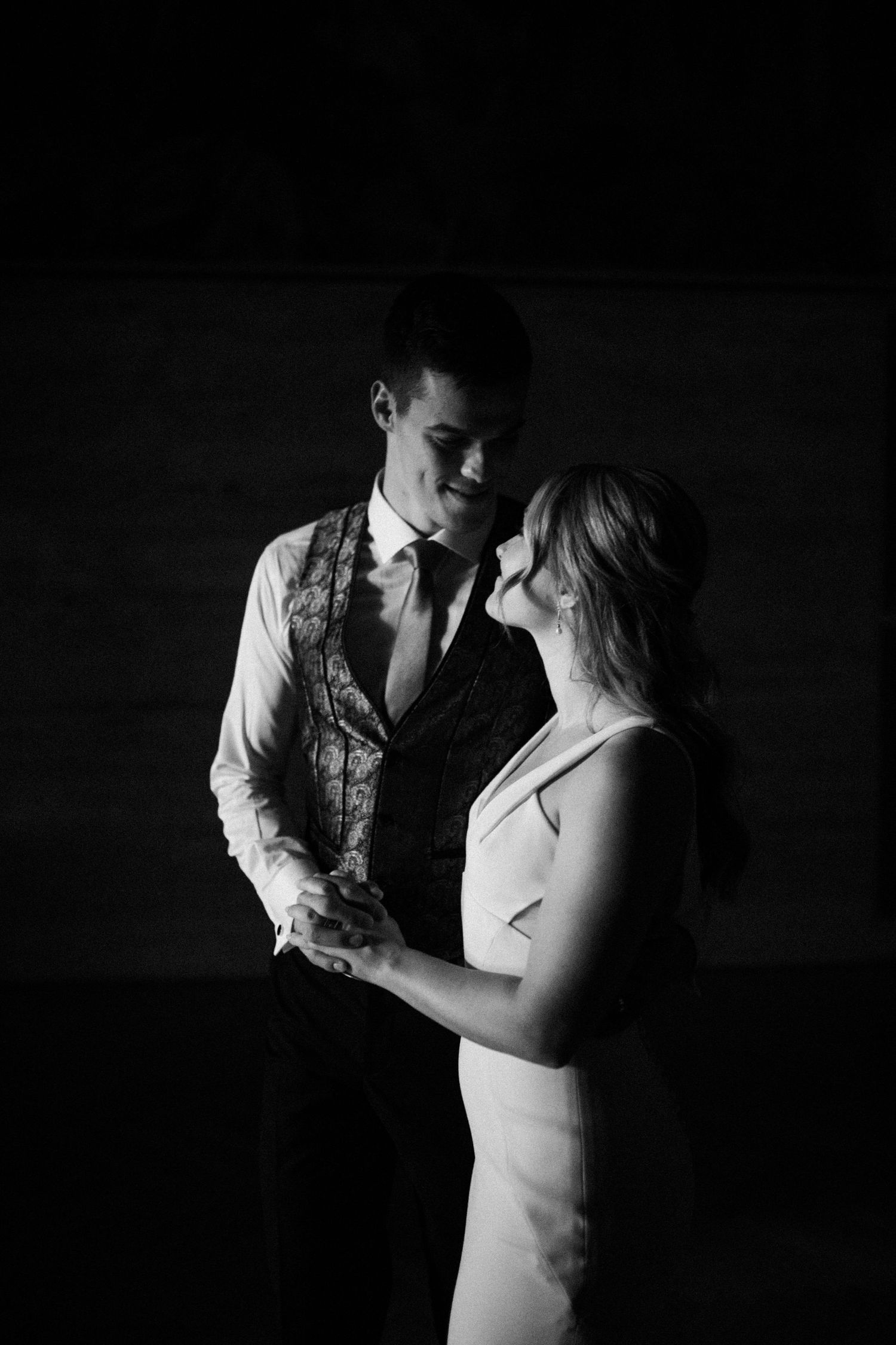 Intimate black and white photos of a couple dancing in dramatic lighting.