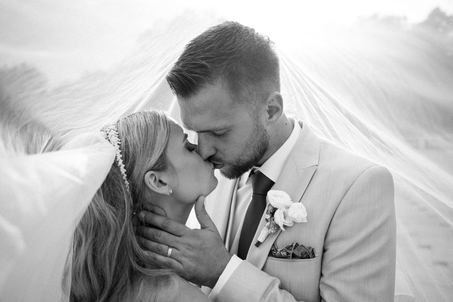 Black and white romantic wedding portrait capturing an intimate moment between newlyweds.