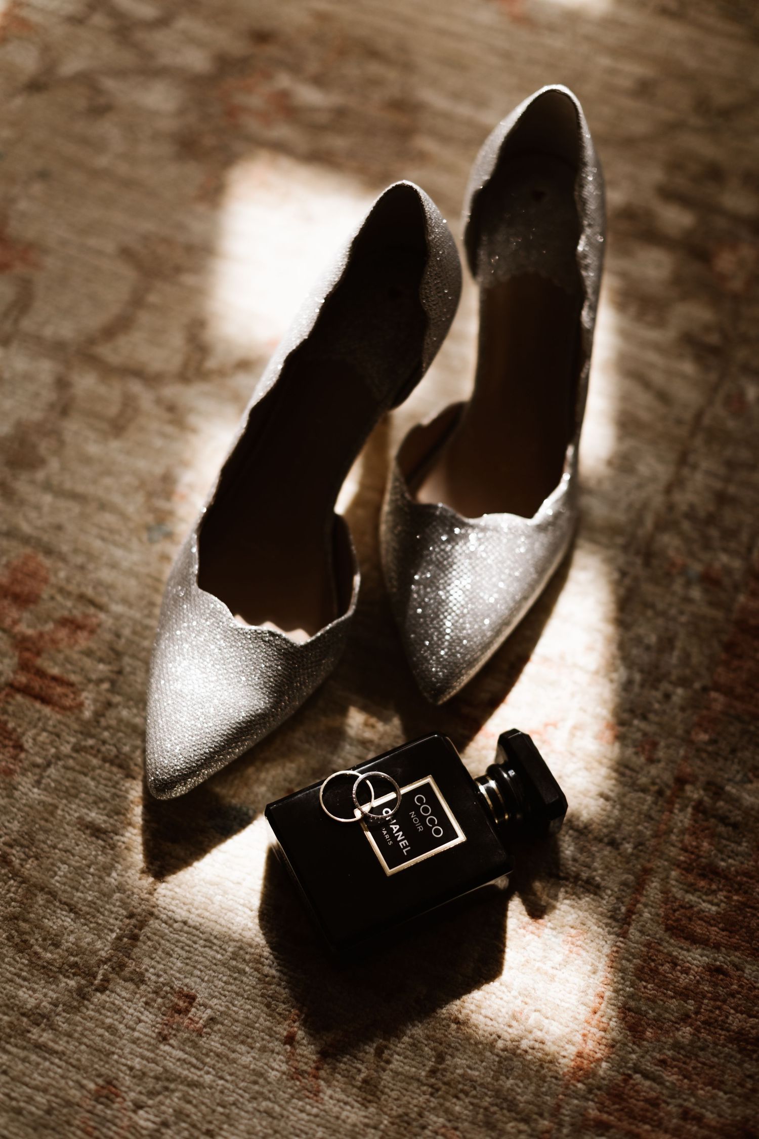 Elegant sparkly bridal shoes arranged artistically in a sepia-toned photo series.