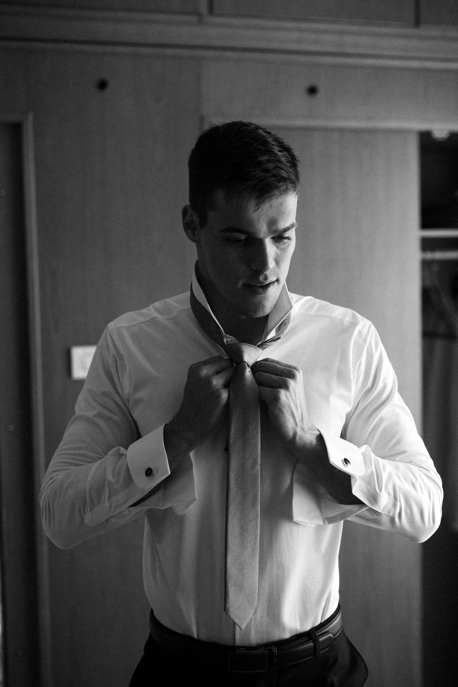 Black and white photo series showing the process of adjusting a formal bow tie.