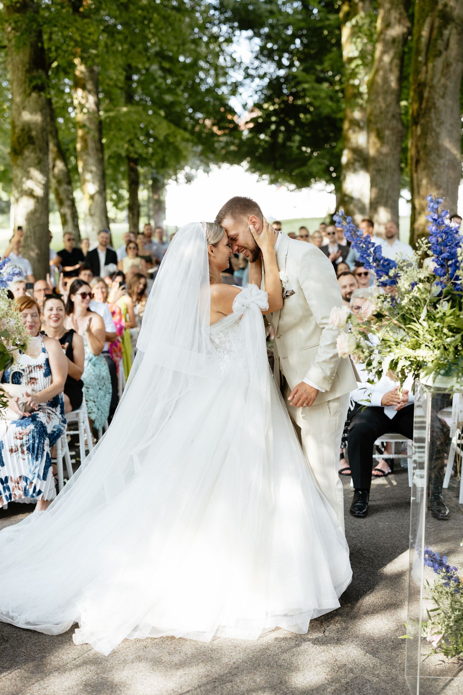 A sequence of wedding photos showing a couple dancing in a tree-lined outdoor venue with guests watching nearby.