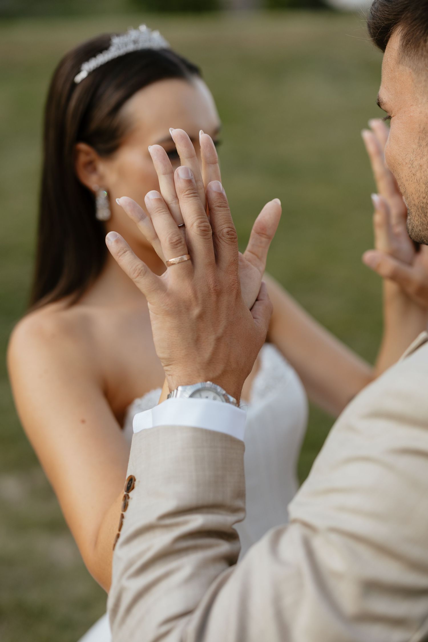 Close-up of wedding rings and intimate moment in natural lighting.