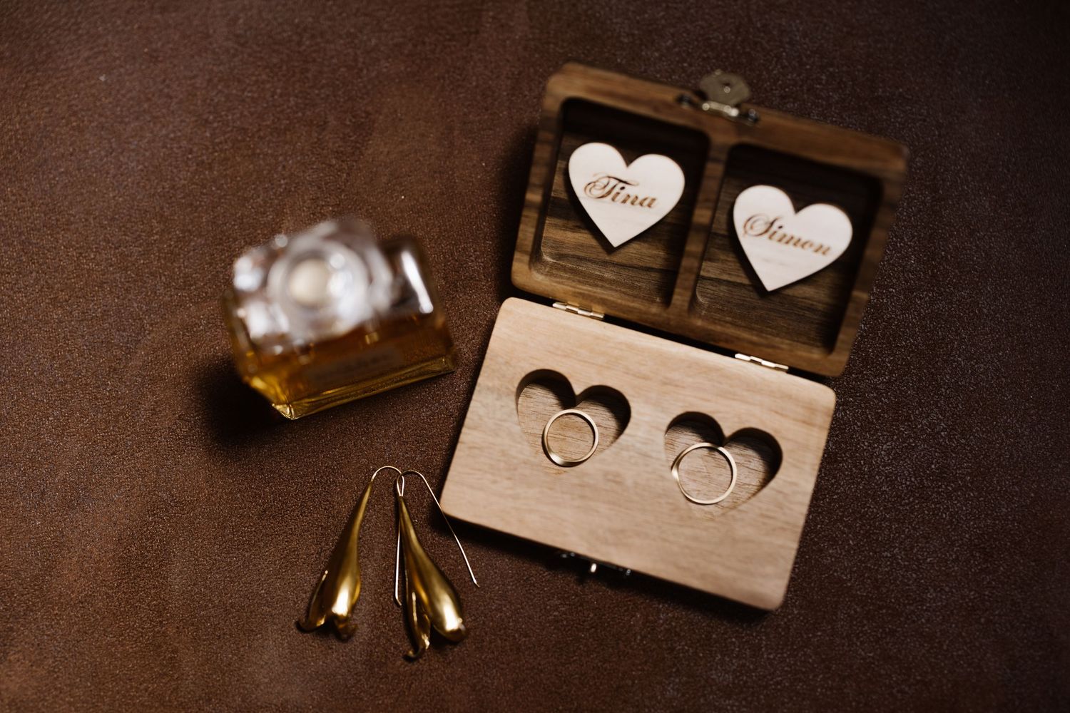 Wooden hearts and decorative elements arranged on a rustic brown background create a romantic vintage composition.