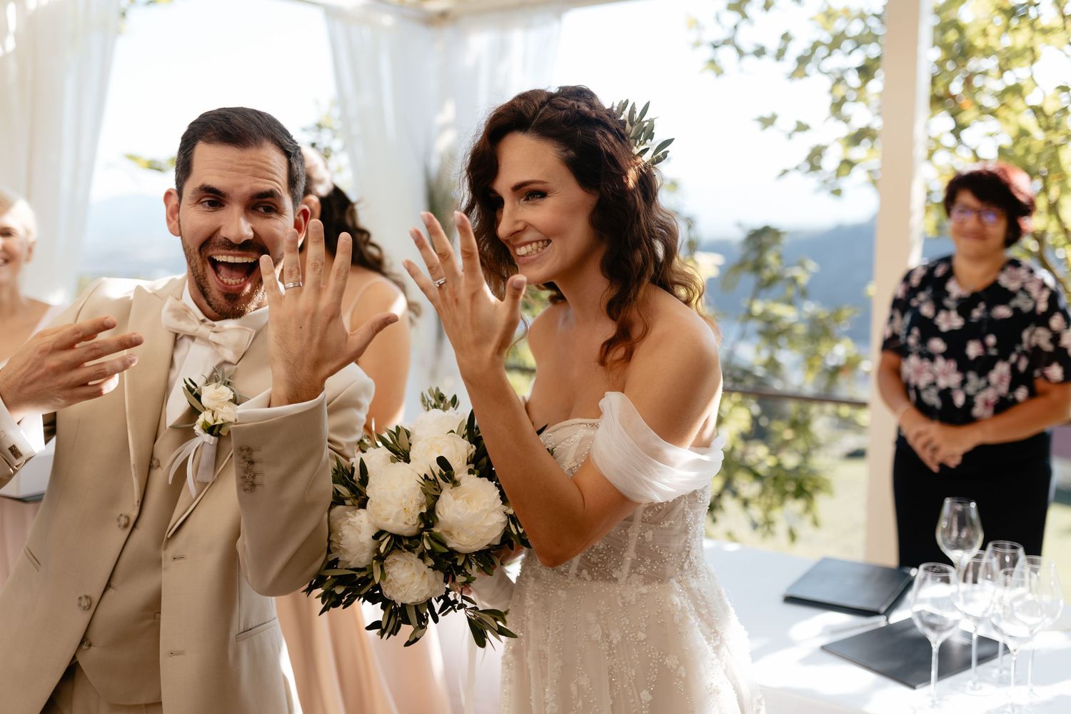 Wedding party celebrates with joyful laughter and smiles during an outdoor celebration.