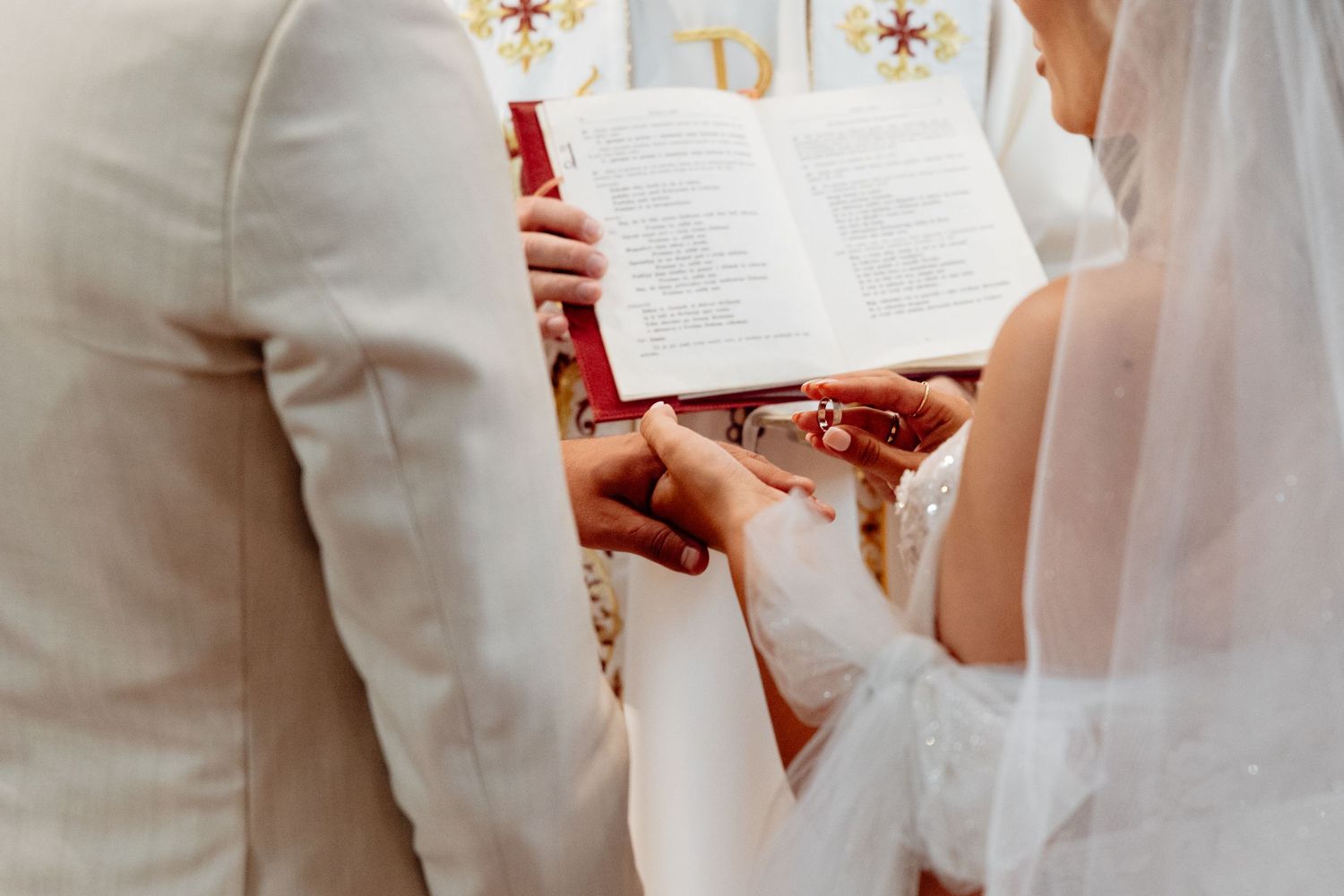 A couple holds a prayer book during their traditional religious wedding ceremony.