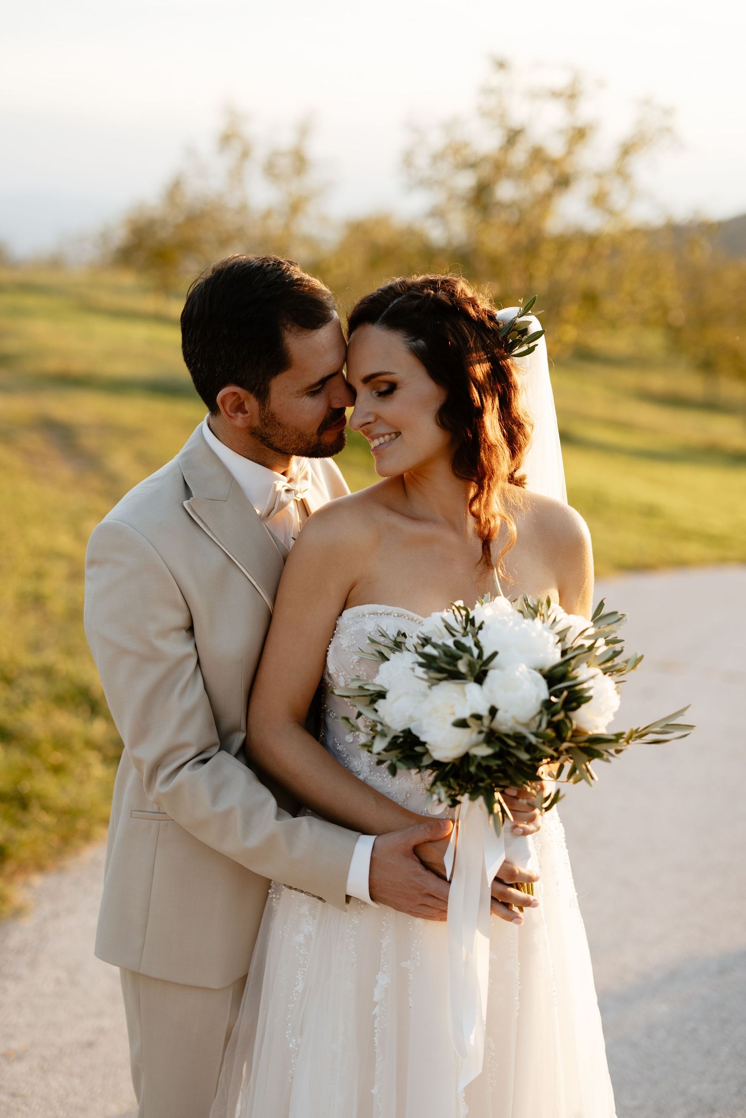 Intimate wedding portraits show tender moments between newlyweds against a warm sunset backdrop.