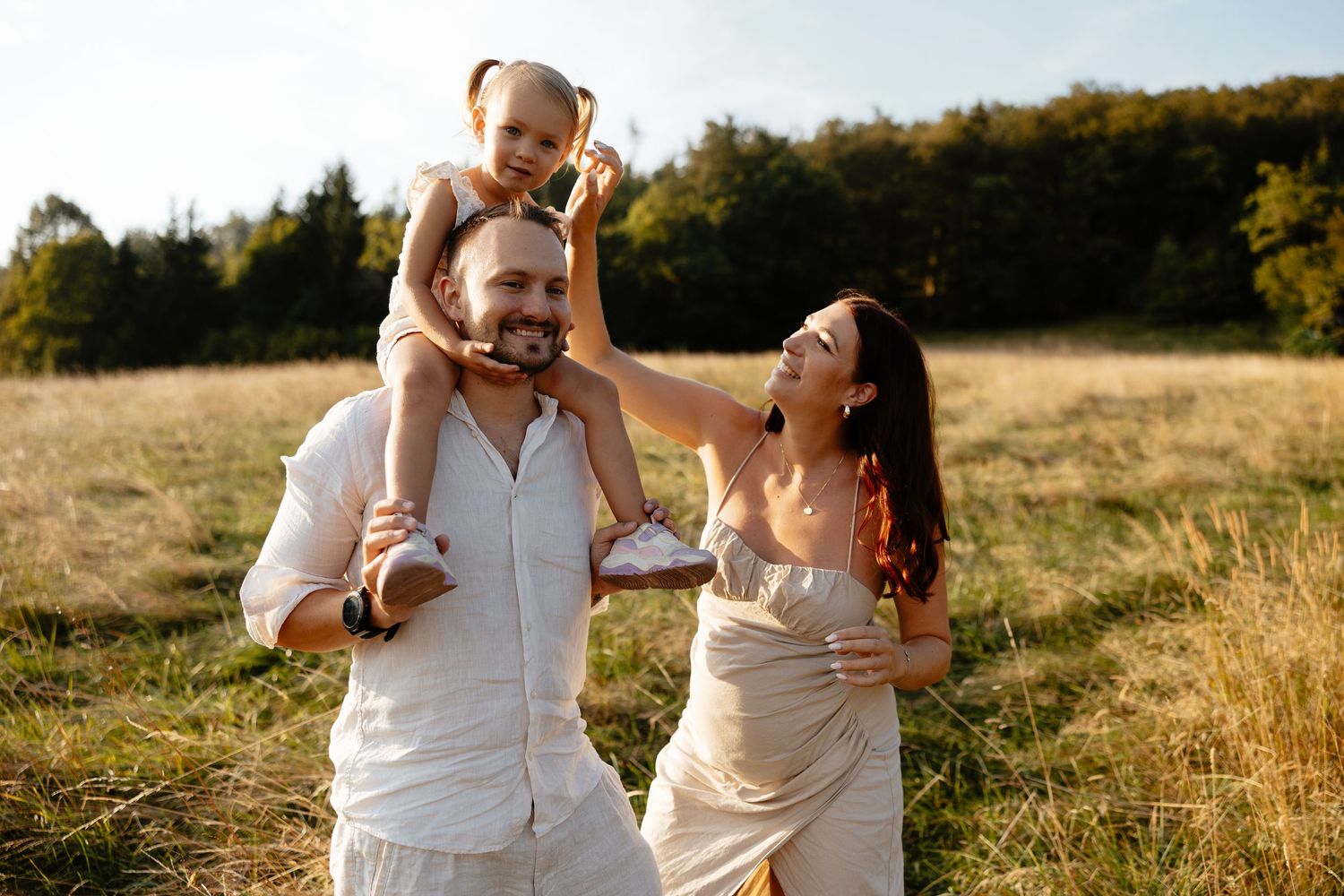 Candid family moments photographed in warm evening light on a hillside.